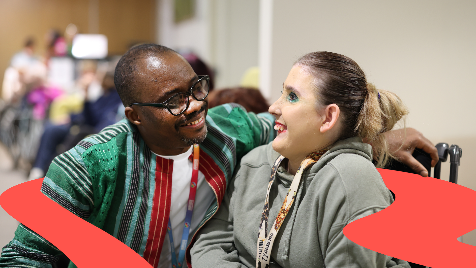 Two people chatting together in a communal care and support environment
