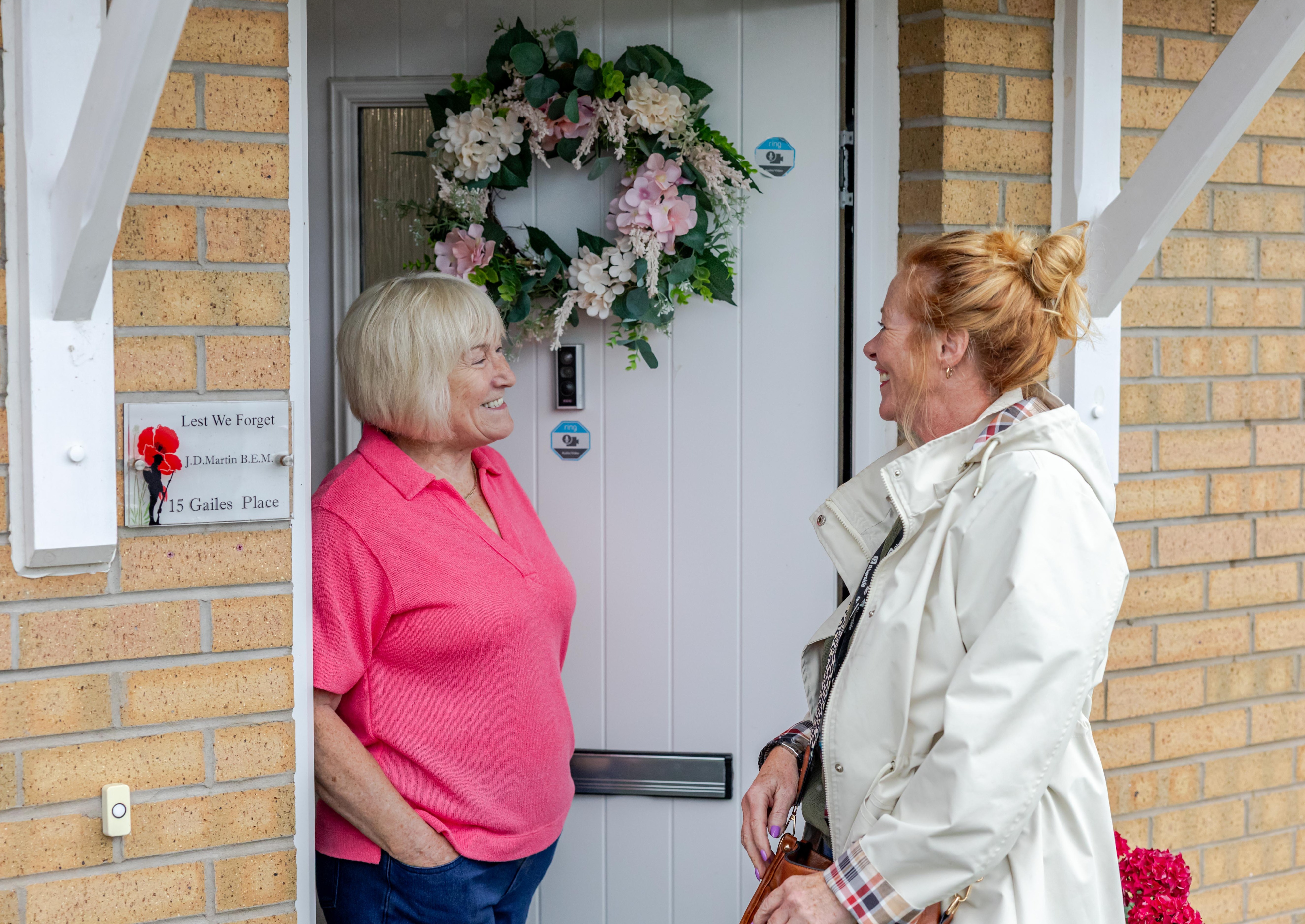 Riverside customer and staff member outside house