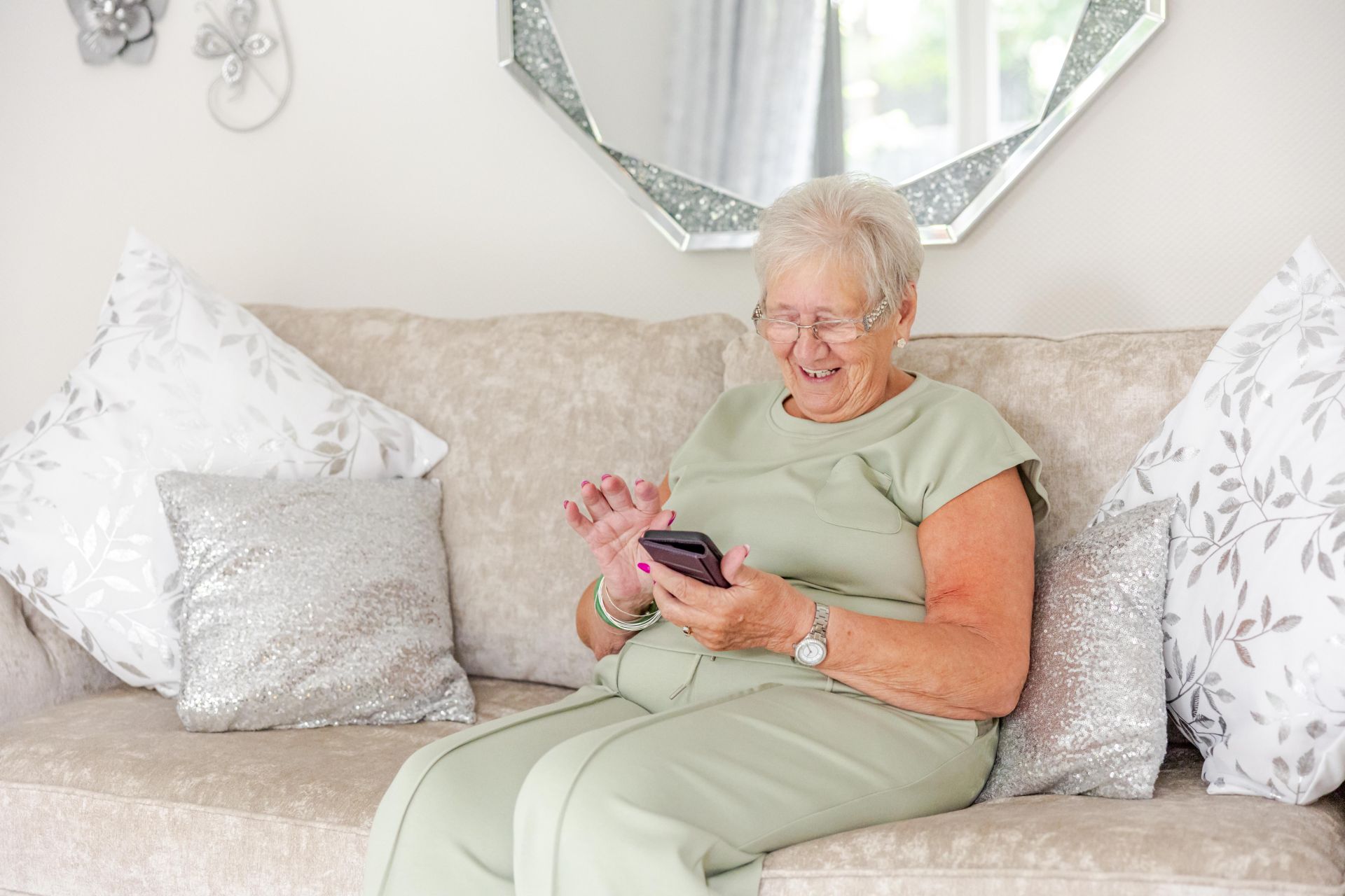 A person sits on a sofa looking at their mobile phone