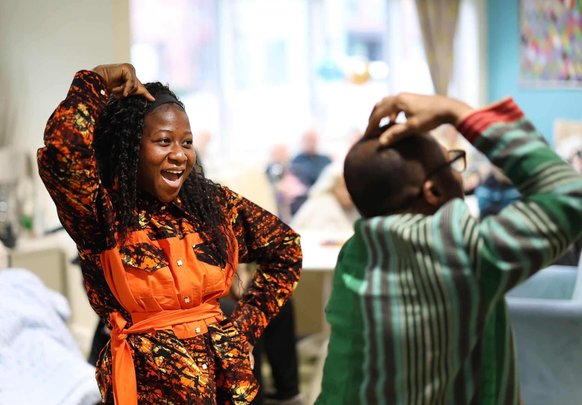 Two people dance together in a communal lounge