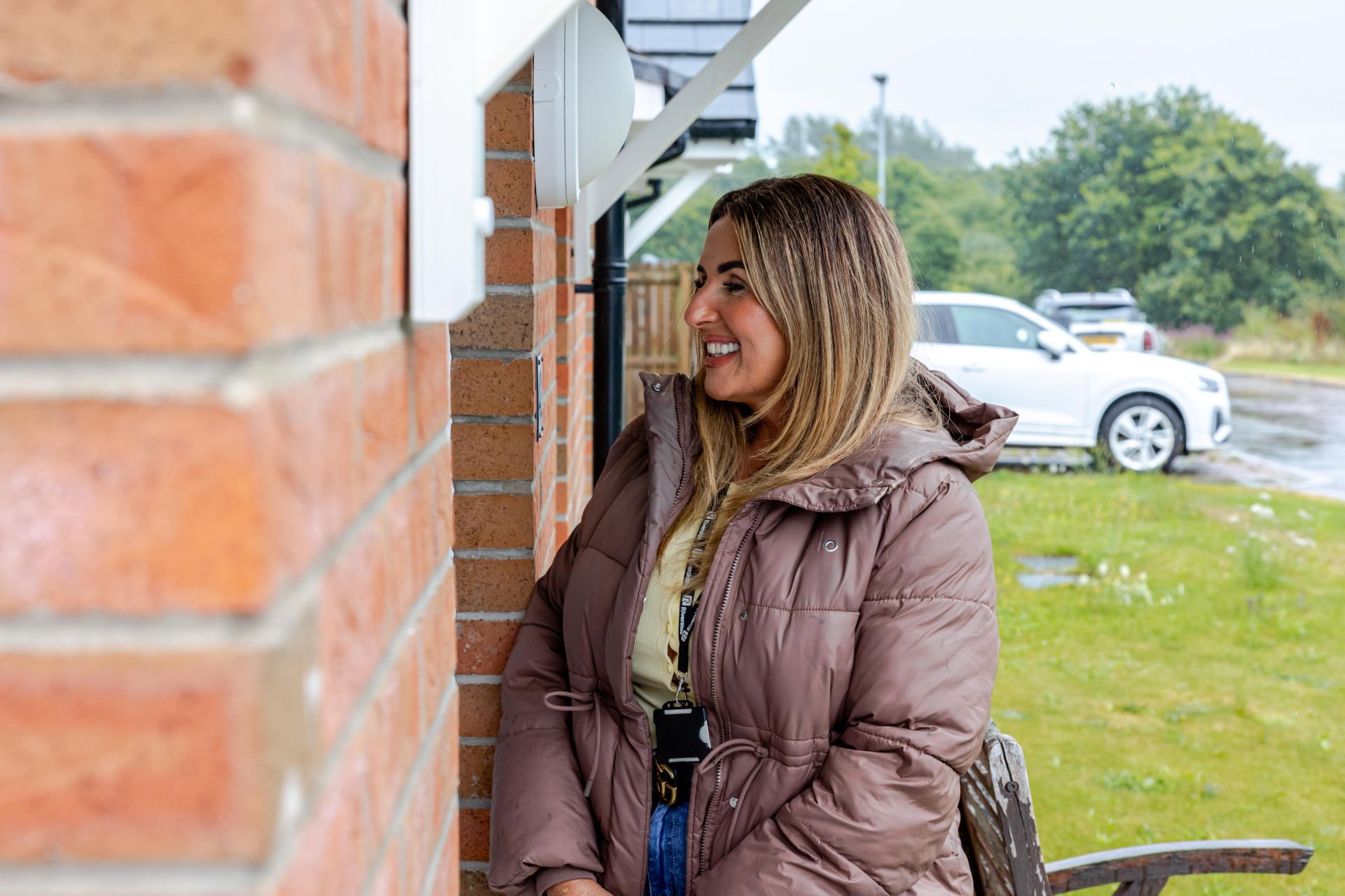A person stands at a doorway smiling