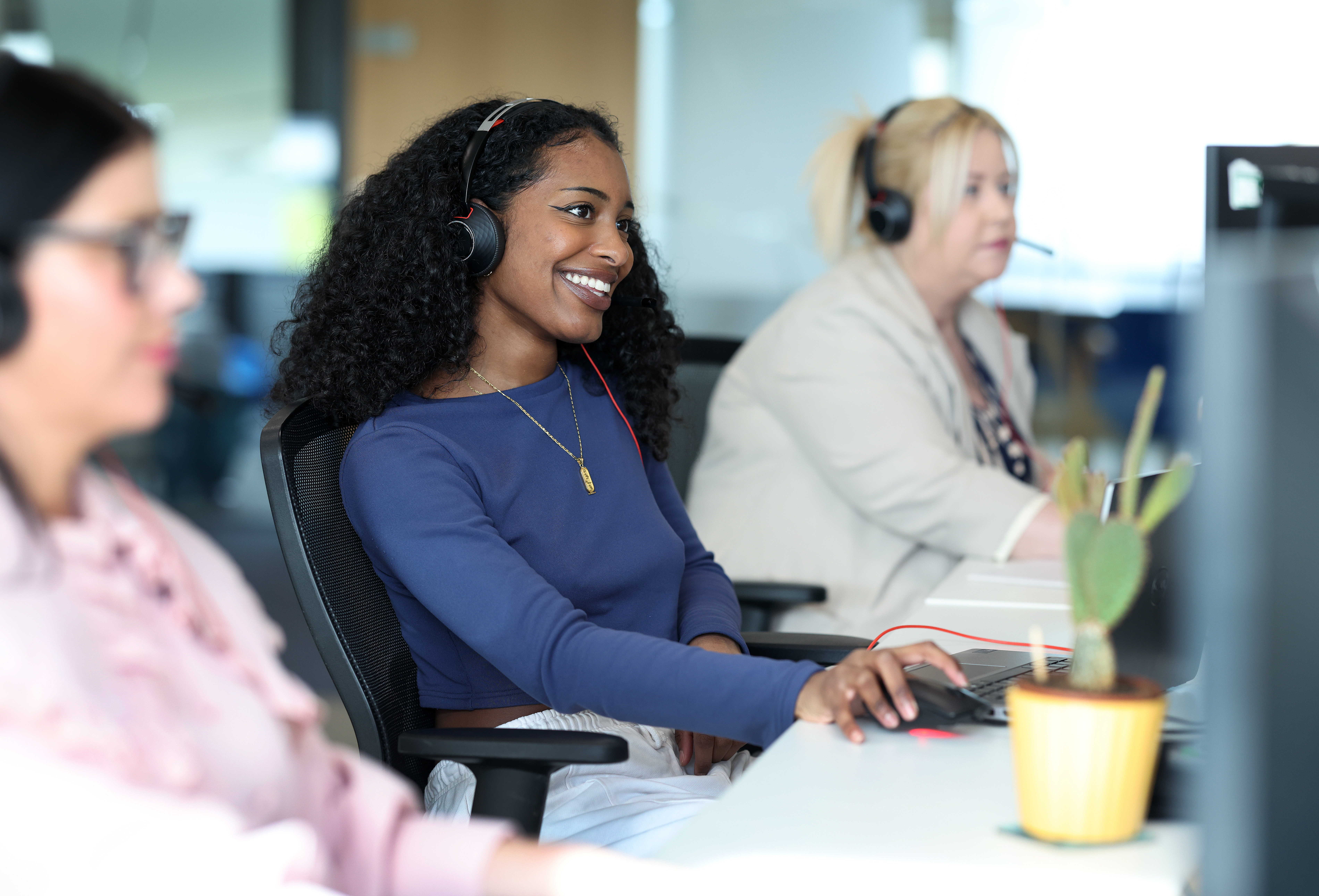 Colleagues at desks wearing headsets